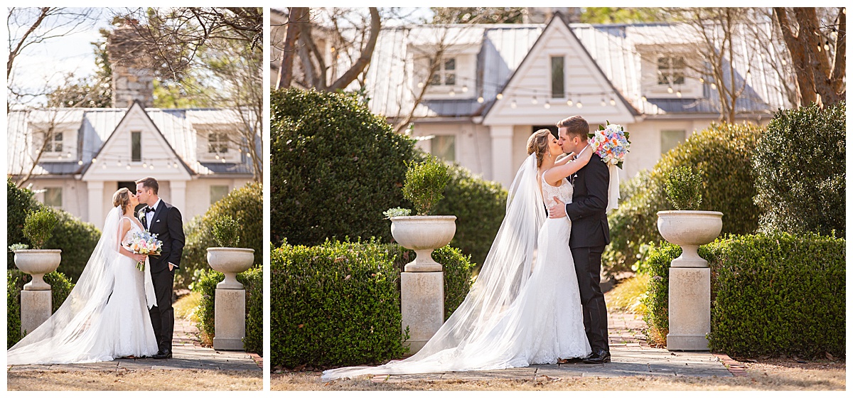 blonde bride with long veil and groom in black tux kissing in front of cottage at long hollow gardens